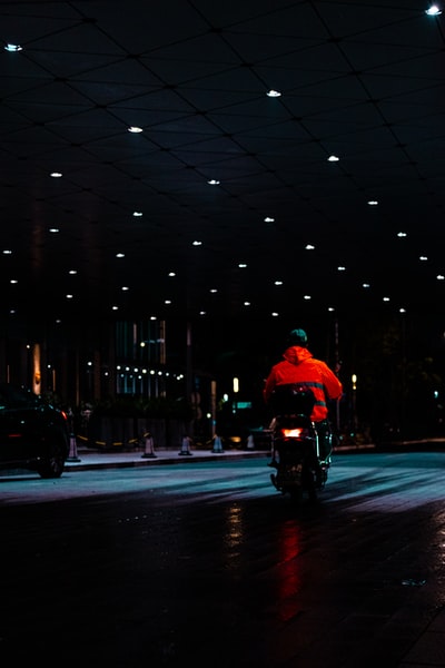 穿红夹克的人晚上骑摩托车上路